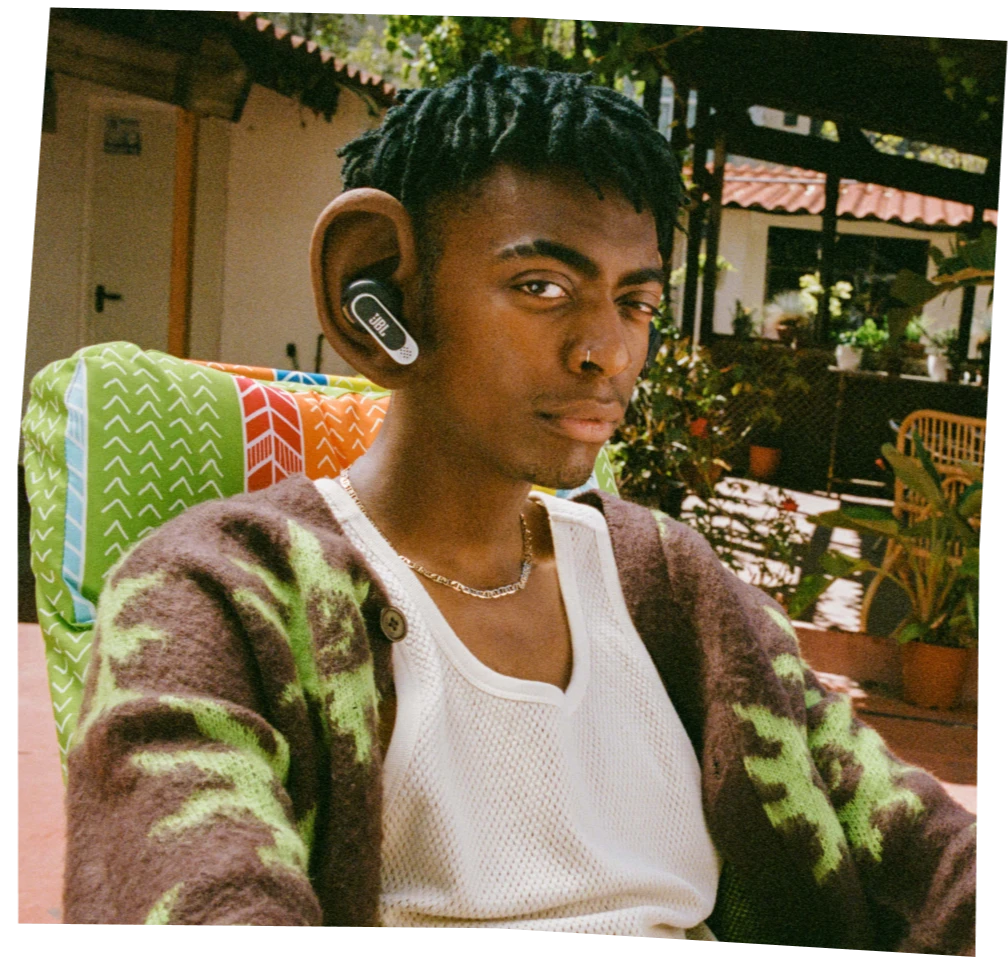 Pria memakai earbud JBL